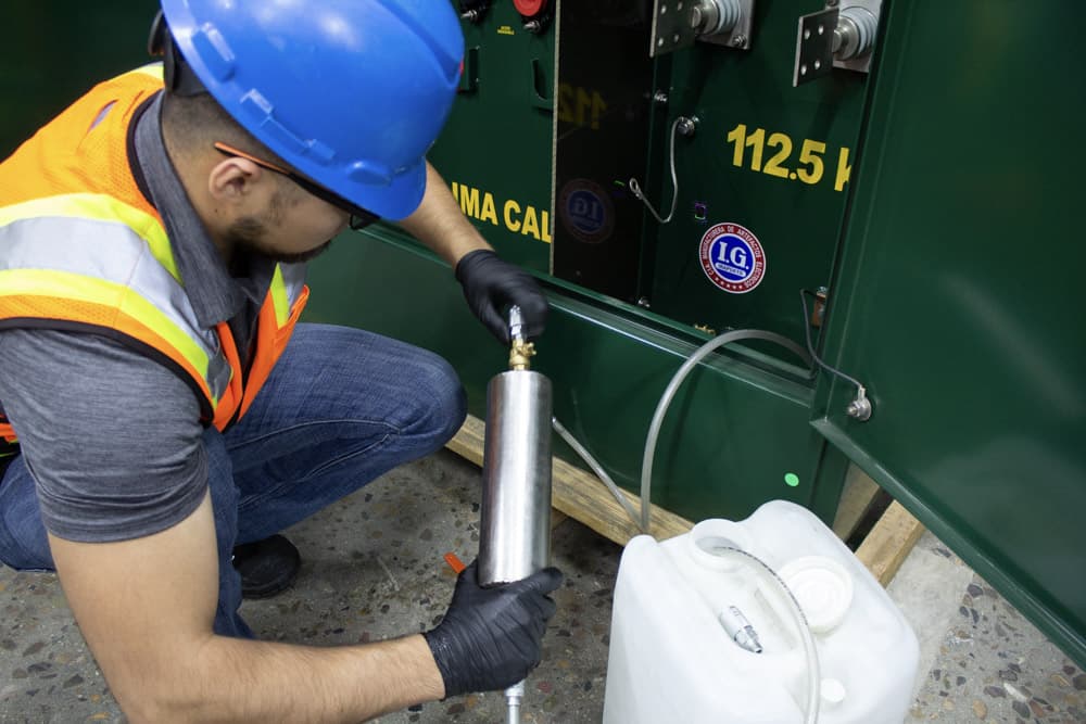 Muestreo de aceite dieléctrico en transformador por técnico especializado.